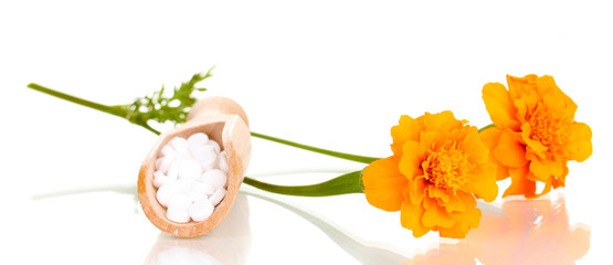 homeopathic tablets and flowers isolated on white