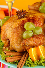 roastes chicken with grapes, lettuce and spices close-up.