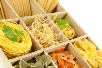 Nine types of pasta in wooden box sections close-up isolated