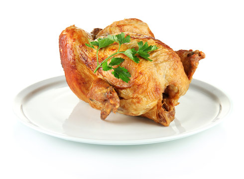 Roasted whole chicken on a white plate isolated on white