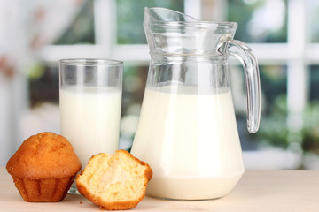 Pitcher and glass of milk with muffins