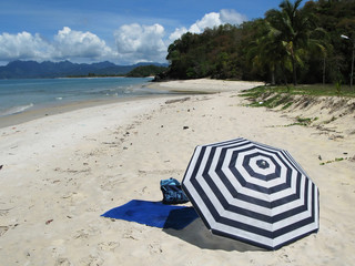 Striped umbrella on a secluded beach of Langkawi island, Malaysi