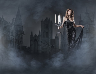 Fashion shoot of a woman in a long dress on a spooky background