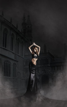 Fashion shoot of a woman in a long dress on a spooky background