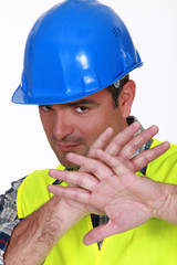 Tradesman holding his hands in front of his face