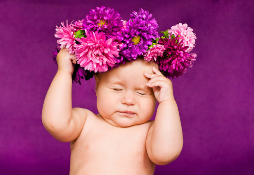 baby with wreath of flowers