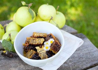 fresh honey combs and apples on wooden garden table