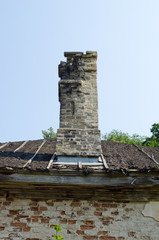 Fototapeta na wymiar Starożytna zawaleniem dachu ściany budynku i komina