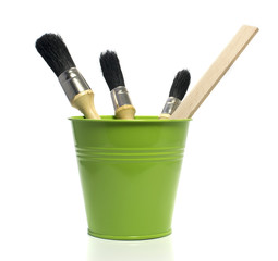 green bucket with paint brushes