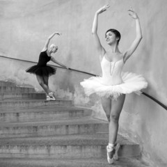 Young beautiful dancers along the stairs. Black and white image.