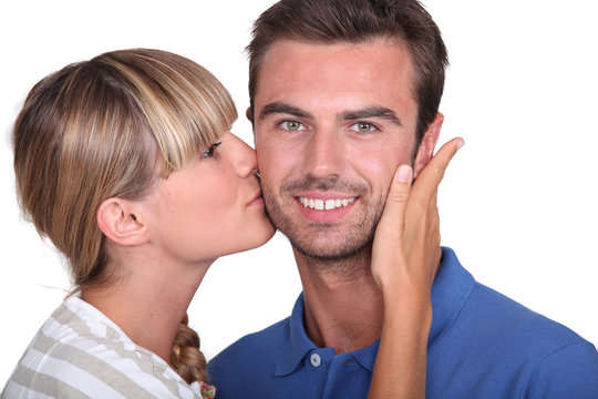 Young woman kissing a man's cheek