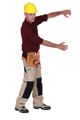 Tradesman framing an invisible object with his arms