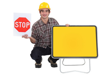 Worker with a blank road sign