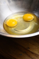 Two egg yolk in metallic bowl