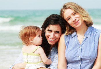 two beautiful girls with a baby on the beach - 45523548