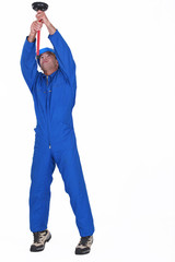 Naklejka premium A plumber unplugging the ceiling.