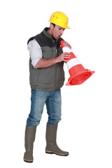 Tradesman blowing into a pylon