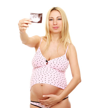 A pregnant woman holding an ultrasound picture
