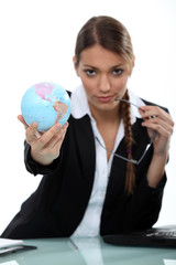 Woman holding up a mini-globe