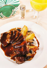 Duck filet with glazed pears on a plate