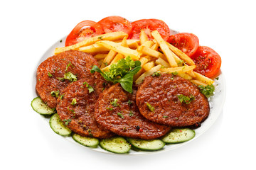 Grilled steaks, French fries and vegetables