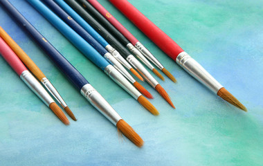 brushes on bright abstract gouache painted background