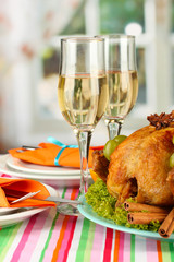 banquet table with roast chicken and glasses of wine.