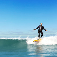 Businessman surfing on the waves of the ocean