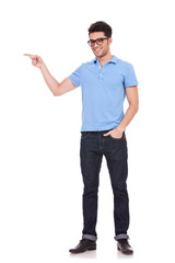 young man pointing with a hand in pocket
