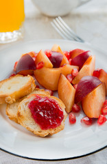 Breakfast toasts with jam, plum and pomegranate seeds