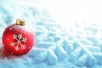 Red christmas ball on snow