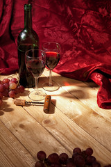 Romantisches Arrangement mit Rotwein,Weintrauben und rotem Samt