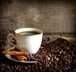 Cup of coffee with beans and cinnamon vintage still life