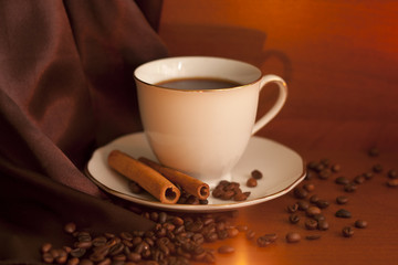 Cup of coffee with cinnamon and beans