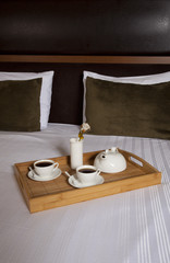 Tray with coffee on a bed in a hotel room 