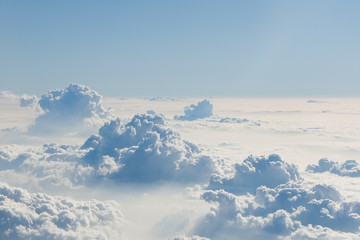 View of blue sky above fluffy clouds. - obrazy, fototapety, plakaty
