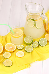Citrus lemonade in glass and pitcher of citrus around