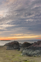 Sunset at sea, rocks in foreground before sea