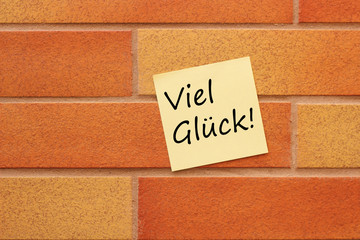 Wand mit gelben Zettel und Text Viel Glück