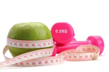 An apple, a measuring tape and dunbbell