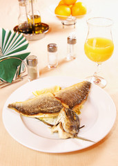 Roasted fillet of Dorada fish on a laid table