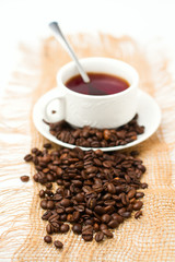 Coffee beans and white coffee cup on white background