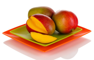 Ripe appetizing mango on red plate isolated on white