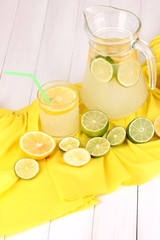 Citrus lemonade in glass and pitcher of citrus around