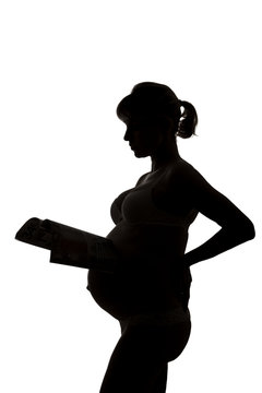Silhouette of the pregnant woman with the magazine