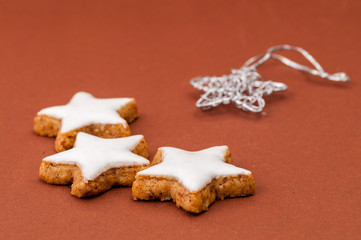 Ein paar Zimtsterne freigestellt vor einem braunem Hintergrund