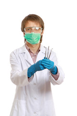 A male dentist with tools in his hands