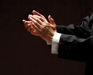 Male hands clapping on black, side-view