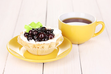 sweet cake with cup of tea on wooden background