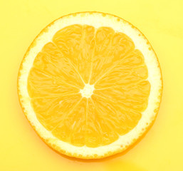 Slice of orange on yellow background